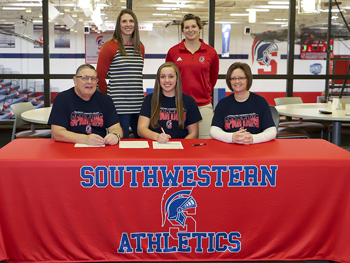 Emma Hanson posing with her family and coaches.