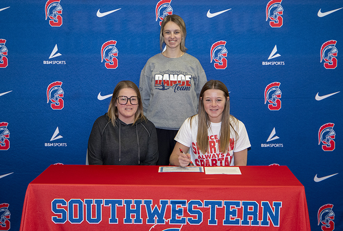 Sitting (L to R): Korie Woollums, Brylea’s mother, and Brylea Woollums. Standing: Paige Russo, Southwestern head dance coach.