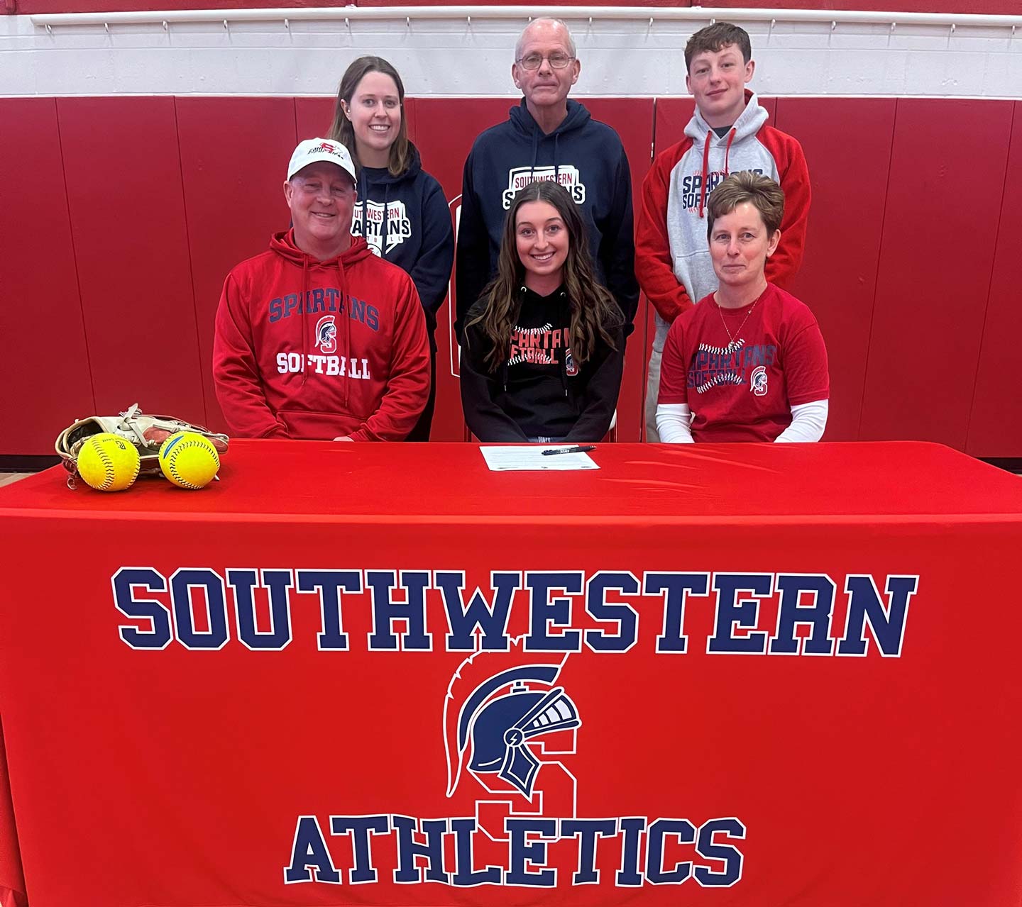 Sitting (L to R) – Dusty Cain, Sydney’s father; Sydney Cain; and Kim Cain, Sydney’s mother. Standing – Abby Nolte, Southwestern associate softball coach; Danny Jensen, Southwestern head softball coach; and Austin Cain, Sydney’s brother.